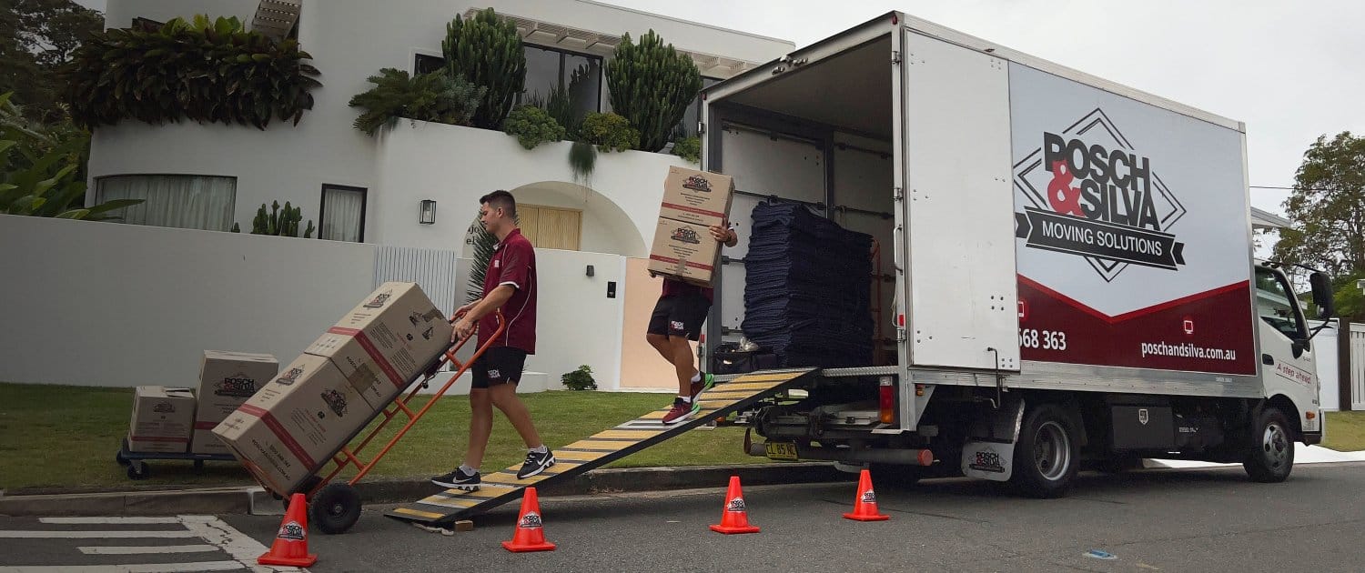Posch & Silva crew wheeling boxes up the ramp of a branded truck outside a Sydney home