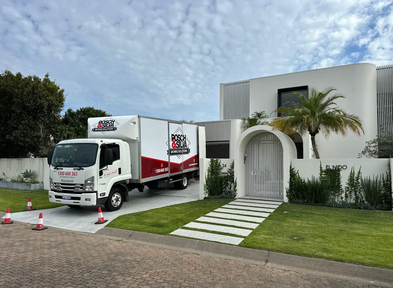 A Posch & Silva removals truck parked outside a modern white house on moving day